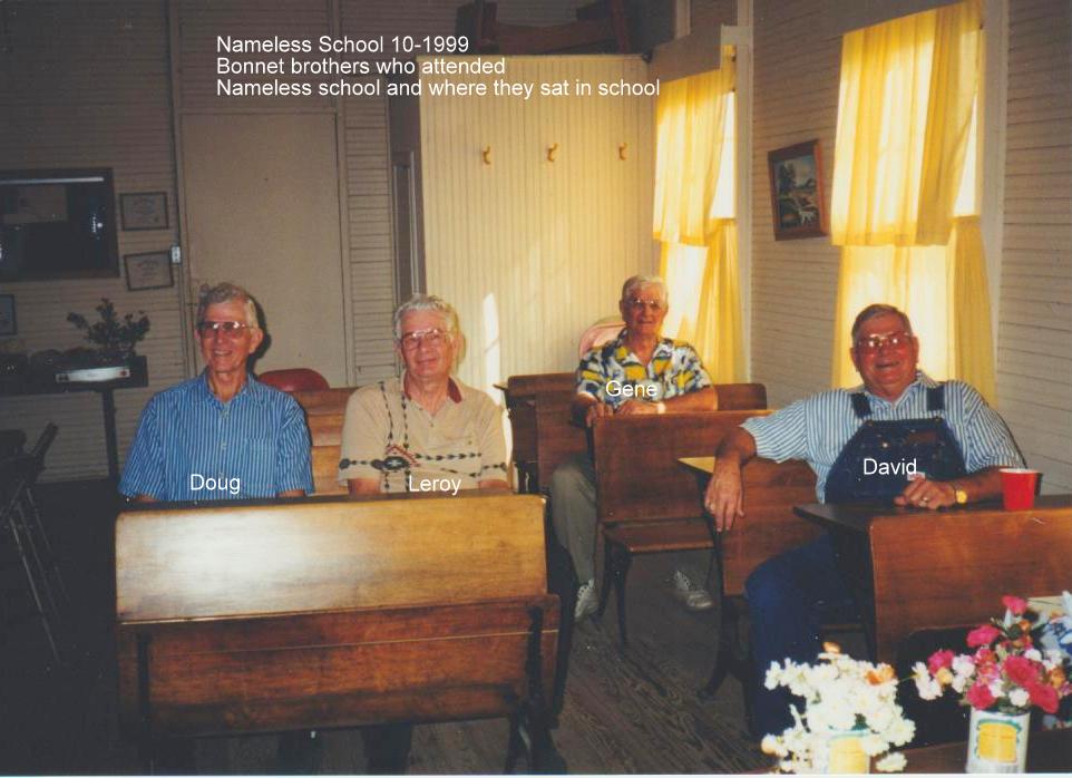 Four Bonnet brothers sitting at their old desks inside the Nameless Schoolhouse, October 1999: Doug, Leroy, Gene, and David