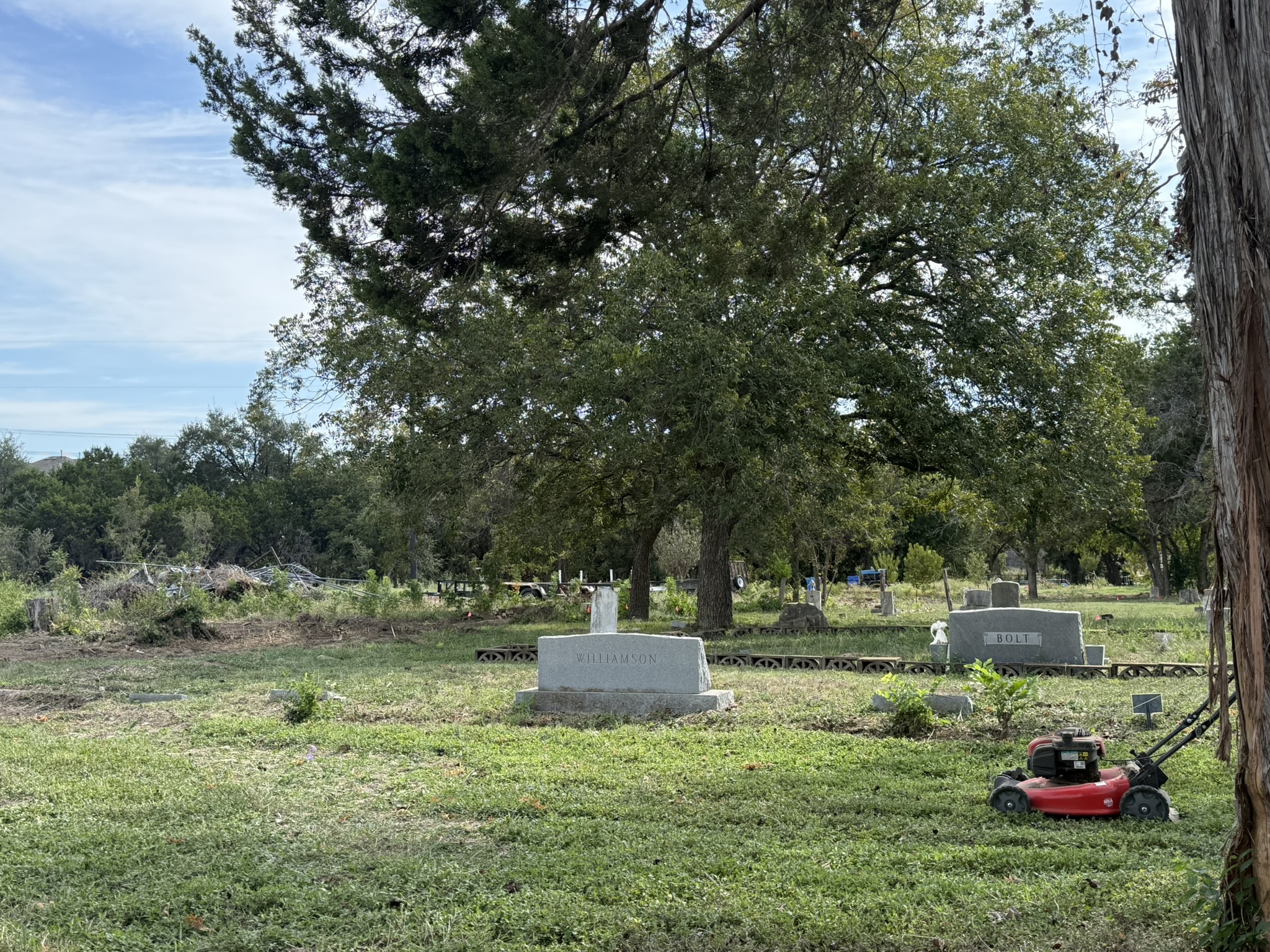 Nameless Cemetery grounds with lawnmower under live oak trees
