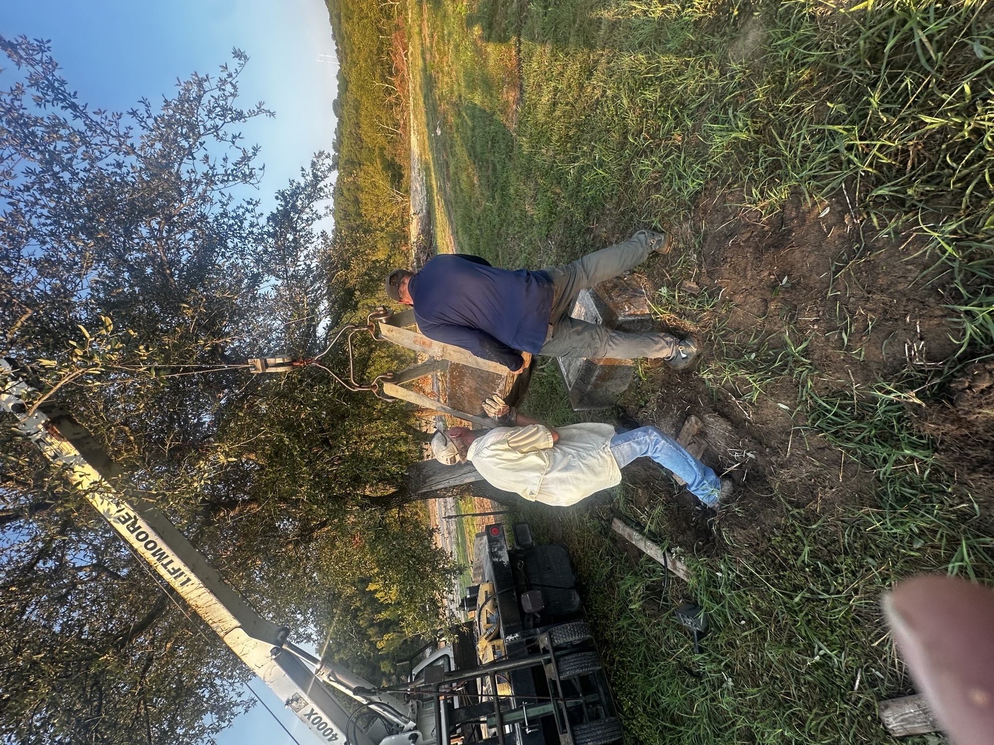 Avalon Monuments workers carefully resetting a grave marker