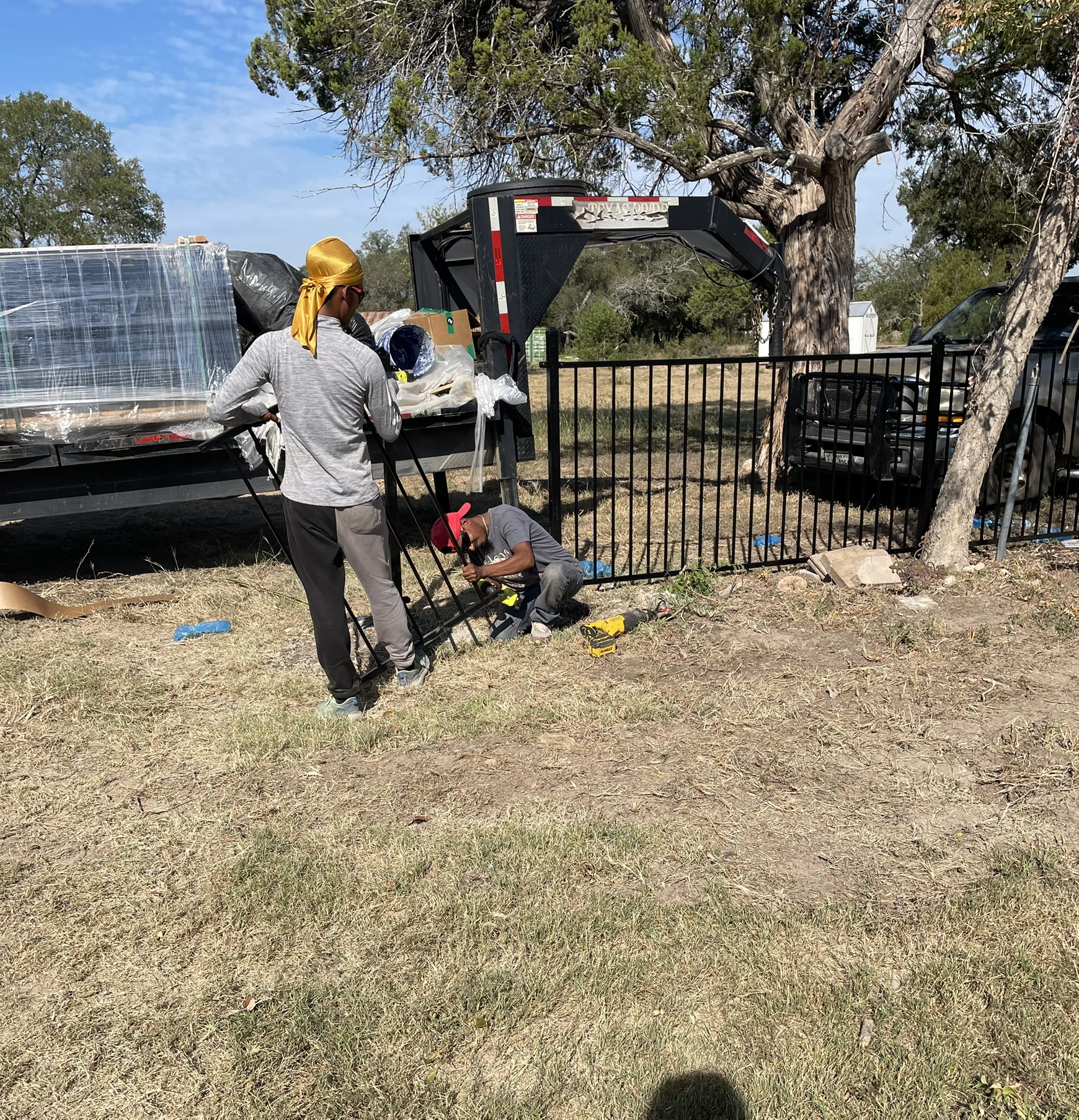 Workers installing the new wrought iron fence and gate arch