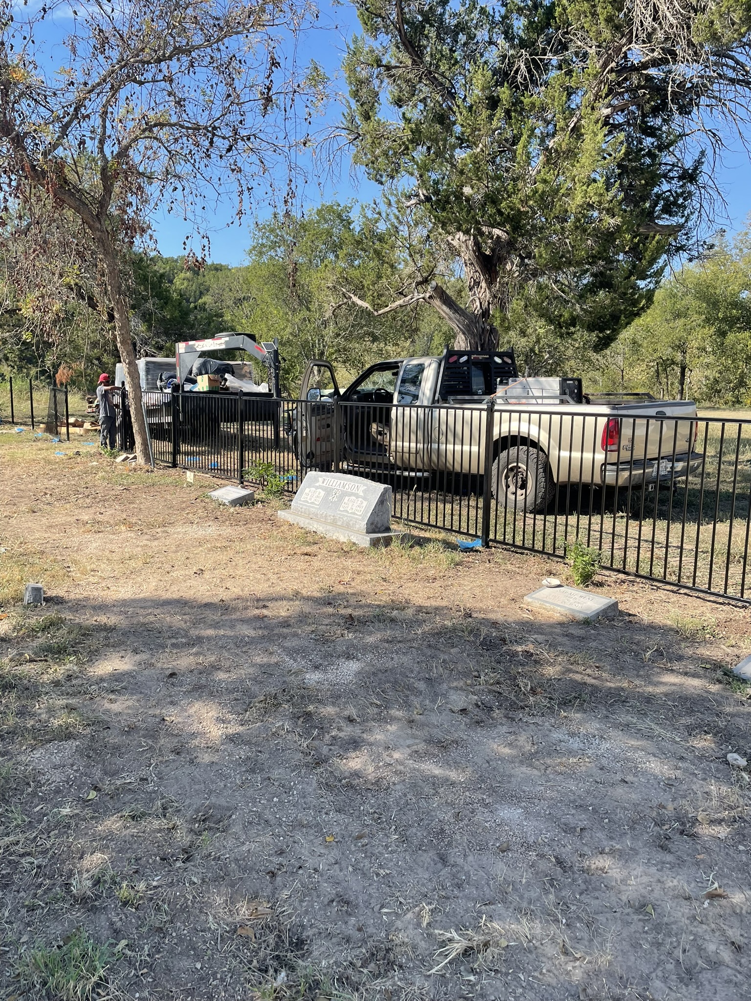 Completed wrought iron fence with gate arch bearing the cemetery name