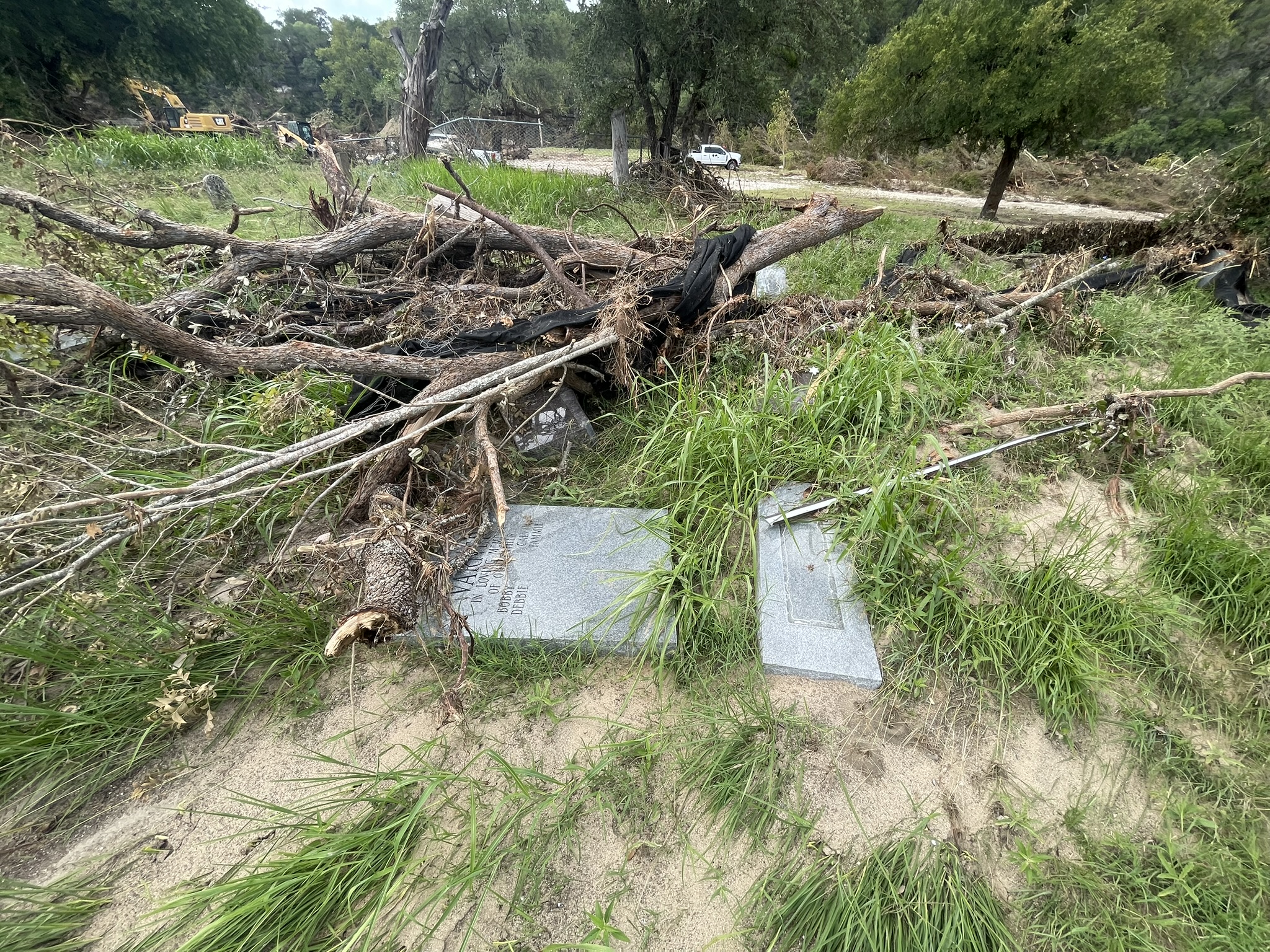 Flood destruction: downed trees and debris covering the cemetery grounds