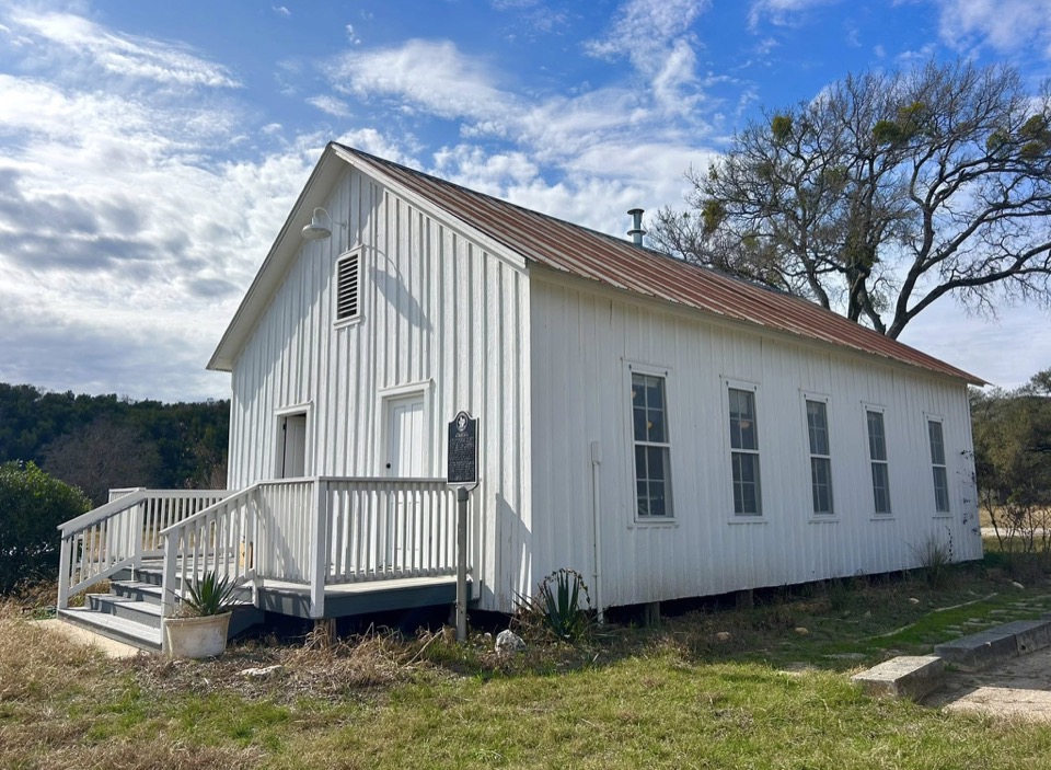 The Nameless Schoolhouse, a white board-and-batten one-room building built in 1909